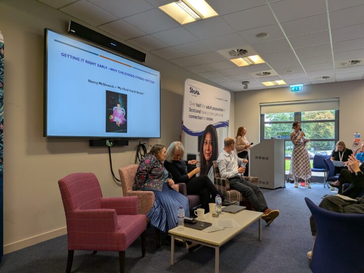 Three speakers on stage during presentation focusing on Childhood Stroke
